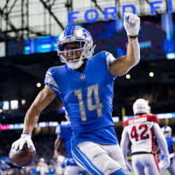 Amon Ra-St. Brown (#14) celebrating a Touchdown catch over the Arizaona Cardinals defender (#42).